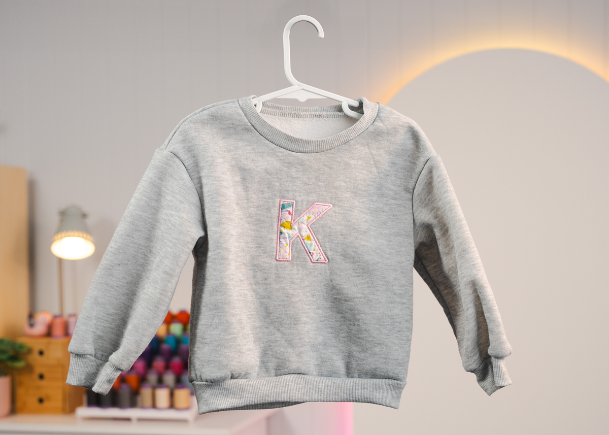 Applique letter on jumper