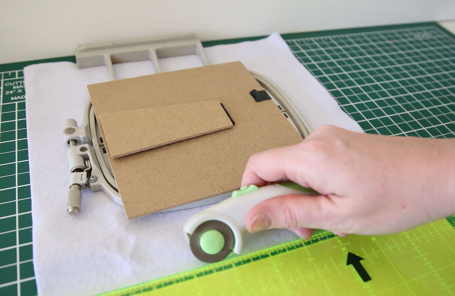 White wool felt measured larger than the embroidery hoop and frame backing board