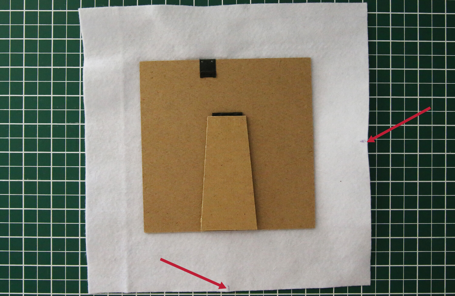 Centred embroidered felt positioned on the frame backing board