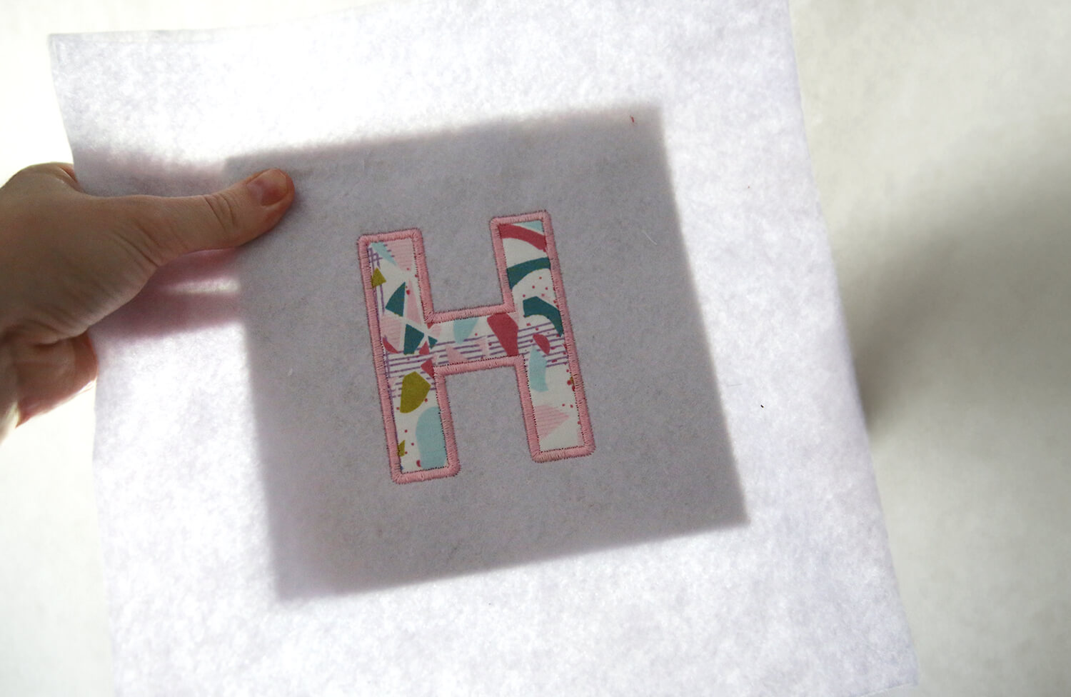 Checking embroidery alignment on the frame backing board using light