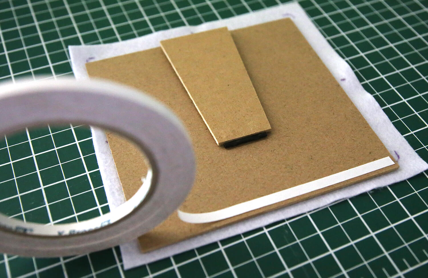 Applying double-sided tape around the back edge of the frame backing board