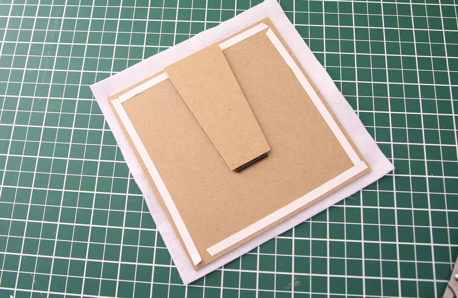 Applying double-sided tape around the back edge of the frame backing board