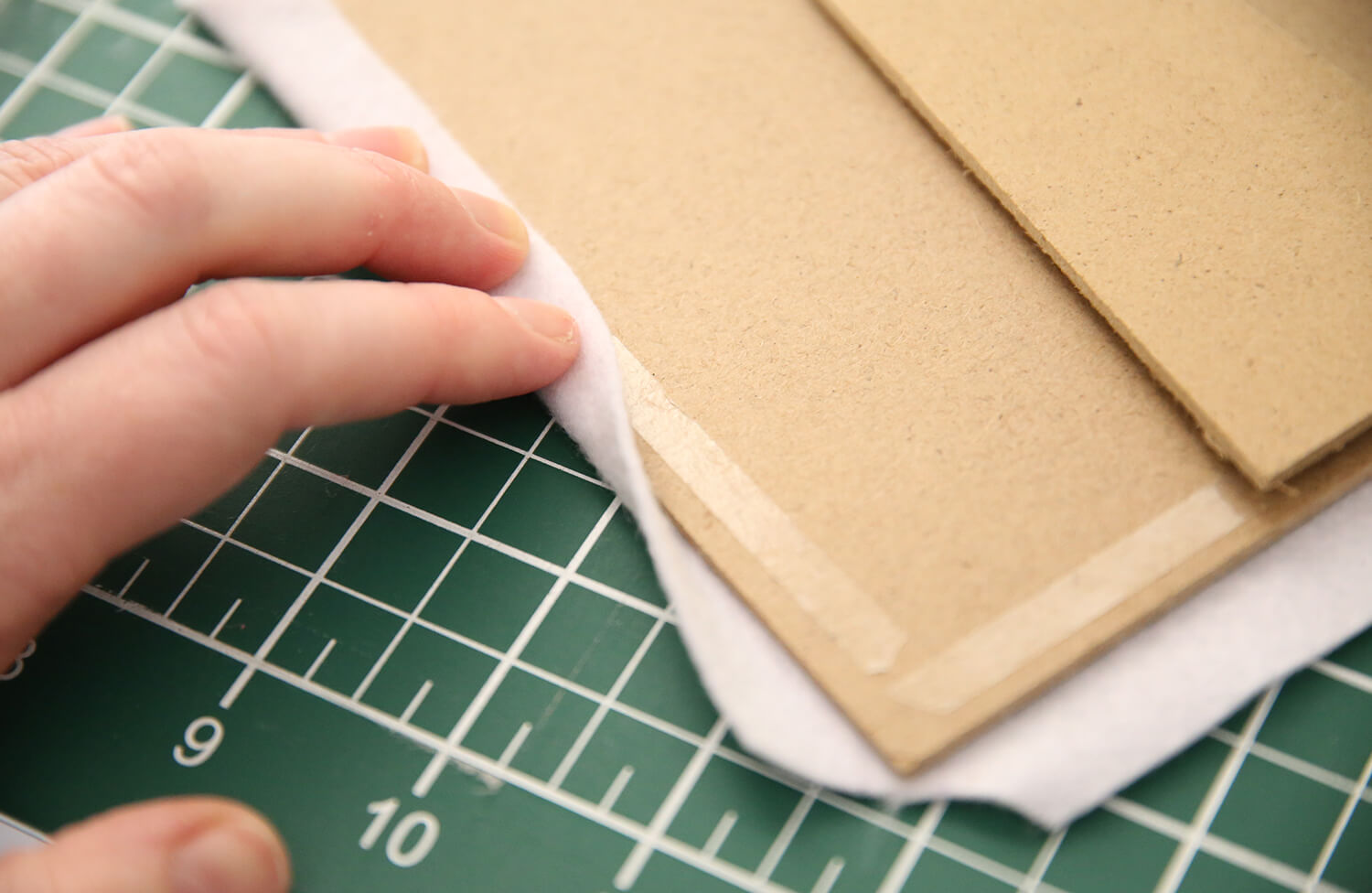 Folding felt edges neatly over the taped frame backing board